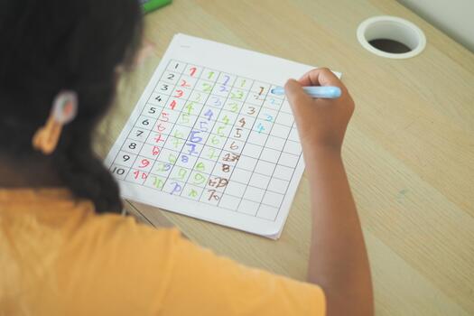 Child solving a colorful number puzzle at a wooden table photo