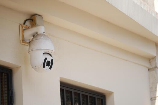 Security camera mounted on building wall near entrance photo