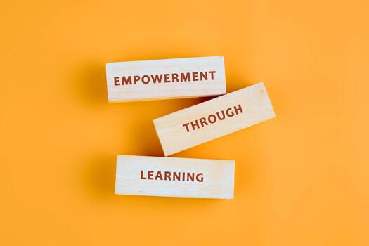 The message connect through learning. EMPOWERMENT THROUGH LEARNING assembled from blocks on orange background, top view photo