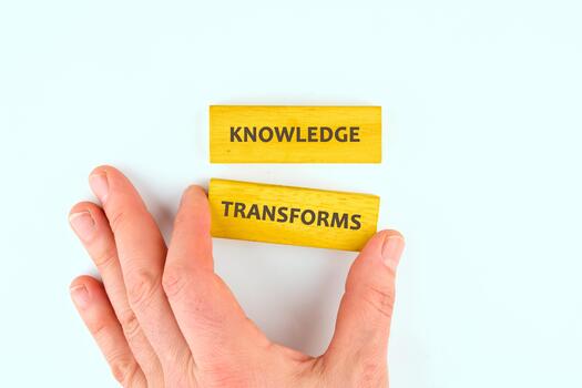 Knowledge learning innovation concept. KNOWLEDGE TRANSFORMS words made from blocks by hand on a light background, top view photo