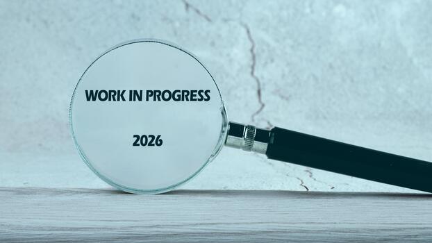 A magnifying glass focuses on the phrase Work in Progress and the year 2026, symbolizing the journey of creativity and planning for future achievements in a minimalistic style photo