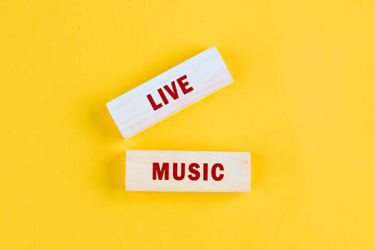 Two wooden blocks showcase the phrase LIVE MUSIC in red letters against a bright yellow background. Simple yet inviting, hinting at the fun of a night out photo
