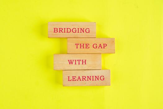 Colorful wooden blocks show text about bridging gaps with learning, highlighting the importance of education and understanding in building connections in our communities photo