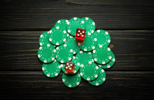 Green chips on a vintage dark table from a successful combination in a game of dice or craps. Low key concept of a gambling and popular game photo