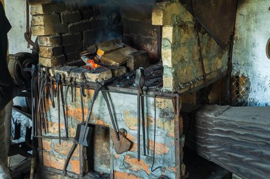 Old smithy with fire before starting work. Working environment with tools in a blacksmith workshop photo