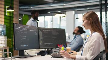 Jeune femelle programmeur en utilisant ordinateur à écrire code, développement machine apprentissage apis. junior développeur dépannage Logiciel les erreurs et défauts en utilisant artificiel intelligence, caméra une video