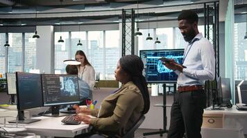 tecnico Il prossimo per ufficio collaboratori sviluppando Software applicazioni, integrando artificiale intelligenza automazione. africano americano uomo Il prossimo per sviluppatori a opera debug applicazioni, telecamera un' video