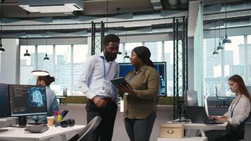 puesta en marcha oficina compañeros de trabajo haciendo lluvia de ideas, desarrollando artificial inteligencia modelos para negocio analítica. equipo de ingenieros corriendo simulaciones para ai impulsado pronóstico, cámara un video