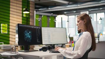Female technician testing machine learning algorithms at work. IT professional scaling productivity with artificial intelligence large language model written code, camera A video