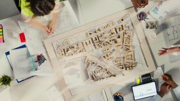 topo baixa Visão ampliação Fora do propriedade desenvolvedores e arquitetos dentro encontro revendo plantas e estrutural projetos. equipe discute projeto aprovação e cidade planejamento para habitação crescimento. Câmera uma. video