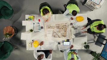 topo baixa Visão ampliação dentro do colegas dentro arquitetura trabalhando juntos em projeto Projeto e desenvolvimento. a diverso funcionários focos em urbano planejamento, e sustentável propriedade investimento. Câmera uma. video