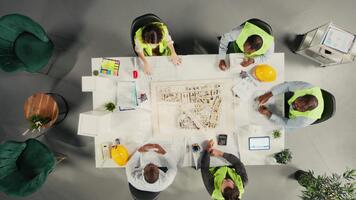 topo baixa Visão ampliação dentro do arquitetos trabalhando em real Estado investimento plano. o negócio equipe análises propriedade dados, habitação plantas e tendências para otimizar terra aquisição e projetos. Câmera uma. video