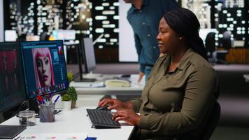 donna esperto sviluppatore lavori con foto la modifica Software e ai, digitale media ritocco e generando contenuto. utilizzando doppio monitor per garantire innovazione nel il grafico design mondo. telecamera b. video