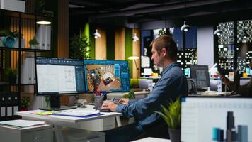 manlig anställd skapar 3d framställa av ett lägenhet interiör använder sig av ritningar och arkitektonisk programvara. dator hjälpte till verktyg och modeller till tillåta anpassning av golv och layout. kamera a. video