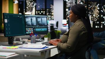 professionell redigering team Arbetar på filma montage på programvara i kontor, digital multimedia skapande. filmskapare och assistent använder sig av dubbel monitorer till redigera antal fot och skapa innehåll. kamera b. video