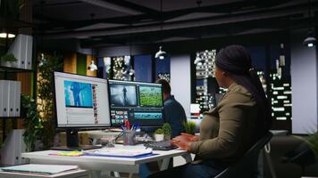 equipo de multiétnico videógrafos edición disparar en enviar producción, utilizando moderno tecnología y edición software para un creativo proyecto. moderno espacio de trabajo con doble monitores cámara una. video