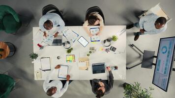 topo baixa Visão ampliação dentro do corporativo empregados colhido dentro uma encontro para discutir finança, Objetivos e propostas. colegas compartilhar percepções, documentos e Métricas para guia projeto planejamento. Câmera uma. video