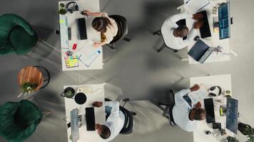 topo baixa Visão ampliação dentro do colegas partilha relatórios e visual dados em computador. trabalhos equipe executa risco avaliação, estratégia planejamento para garantir Forte desempenho e progresso. Câmera uma. video