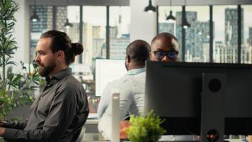 diverso colegas de trabalho dentro escritório trabalhando em analytics e previsão. profissional funcionários Reveja visual dados, diagramas, e documentação para realçar gestão e o negócio Objetivos. Câmera b. video