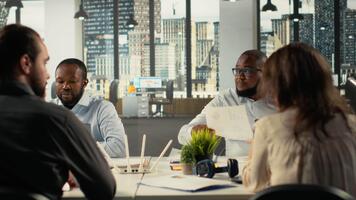 trabalhos equipe acionado dentro negociação e projeto consultando durante o negócio reunião. empregados usar laptops para analisar finança dados, Métricas, e desempenho relatórios dentro uma Sombrio escritório contexto. Câmera b. video