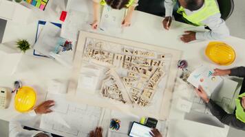 tid upphöra topp ner se zoom ut av verklig egendom utvecklare och arkitekter i kontor granskning ritningar och 3d modeller. utveckling team diskuterar urban planera och fast egendom investering. kamera a. video