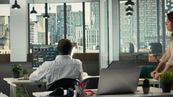 secretário ajudando colegas com arquivado arquivos dentro moderno ambiente de trabalho, revendo gráficos e análise. empregados discutir projeto progresso, relatório escrevendo e dados visualização. Câmera b. video