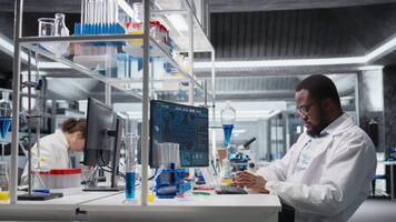 calidad controlar analista en laboratorio analizando indicador solución a puesto de trabajo utilizando ordenador personal software. laboratorio personal miembro pruebas químico fluido muestra usado para experimentos con computadora programa, cámara un video