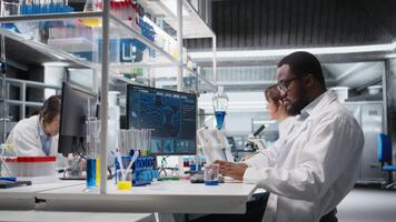 histologi tekniker använder sig av pipett till extrahera reagens från glas in i testa rör på laboratorium bänk. forskning anläggning arbetstagare på pc skrivbord gör pipettering procedur med droppare, kamera en video