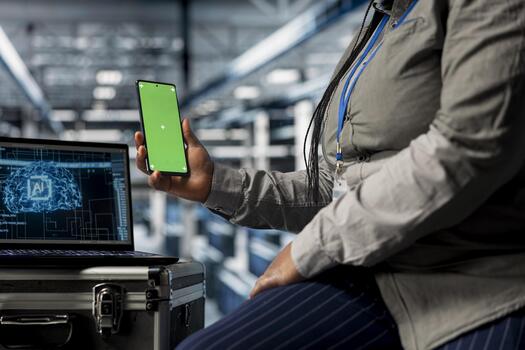 Close up of AI data center admin using green screen smartphone to check messages while taking break. Server hub IT specialist scrolling through social media during downtime at work using mockup phone photo
