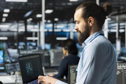 Engineer in server room using AI LLM assistant on laptop to review hardware diagnostics. IT specialist in data center analyzing performance data using large language model to maintain system uptime photo