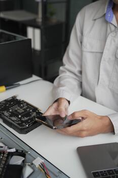 Computer Hardware dissemblers fixing computer PC, using phone. photo