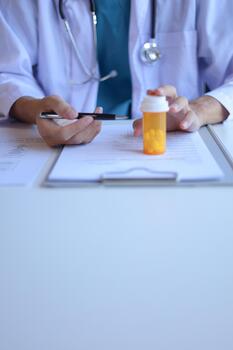 Doctor or General practitioner explain to patient how to use prescribed medicine correctly by explain dosage, frequency, and timing. Vertical. photo