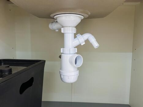 Plumbing connection setup, Preparing plumbing system for appliance attachment and testing, Assembling dishwasher drain connection with supporting clamps and connection points for leak photo