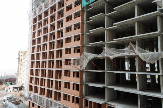 building process with visible materials, unfinished structure showcasing concrete and brick elements, scene of developing industrial building with exposed concrete and brick surfaces in progress photo