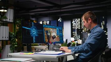 interiör designer ingenjör använder sig av ai neuralt nät till hjälp skapa möbel och layout av ny lägenhet byggnad, arkitektonisk programvara för golv planen på arbetsstation. dubbel övervakar. kamera a. video