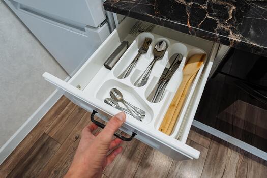 decluttering silverware drawers systematically, arranging utensils efficiently for cleanliness and easy access, strategically organizing kitchen utensils for maximum orderliness and convenience photo