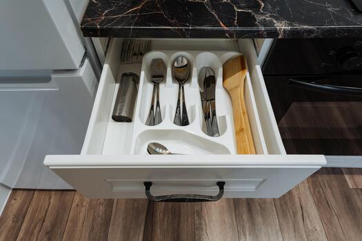 organized silverware on marble surface, sophisticated utensil display highlighting refinement and cleanliness, host arranging polished silverware amidst sleek cabinetry and soft illumination photo