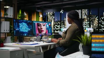 African american woman photographer uses neural networks system to edit photos, creating professional content with artificial intelligence. AI powered software for retouching on pc. Camera A. video