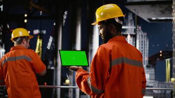 isolerat krom nyckel med arbetare övervaka olja borrning operationer på offshore plattform, använder sig av teknologi till extrahera naturlig gas och fossil bränslen från hav ekosystem. kamera b. video