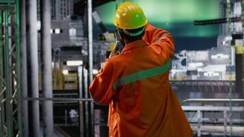 offshore arbetare under de aurora borealis tala via walkie prat och övervakning borrning system, fokusera på fossil bränslen extraktion operationer på natt. hav ekosystem. kamera b. video