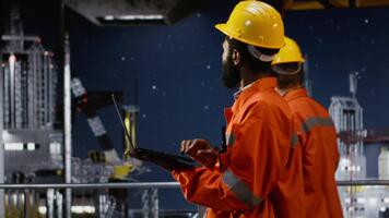 offshore plattform arbetstagare utvärdera risk bedömning rapporter använder sig av bärbar dator, säkerställa effektiv förvaltning av olja och naturlig gas extraktion. fossil bränslen produktion industri. kamera b. video