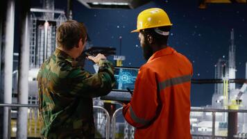 al largo ingegnere e navale ufficiale utilizzando ai tecnologia su il computer portatile per ispezionare perforazione operazioni, Lavorando con il costiero comando inviare per garantire sicuro olio estrazione attività. telecamera b. video