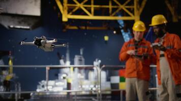 Professional drone operators flies a UAV around a drilling rig, using remote control and camera systems to evaluate the condition and ensure safety on platform, oil production. Camera A. video