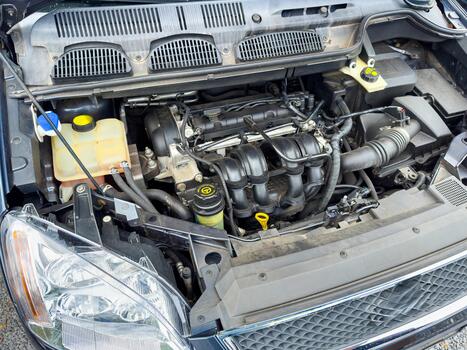 Exploring the intricate details of a car's engine compartment during a routine maintenance check in bright daylight photo