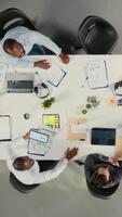 vertical topo baixa Visão ampliação dentro do funcionários dentro multinacional companhia escritório avaliações diagramas e o negócio gráficos. colegas de trabalho partilha intuições e projeções para realçar corporativo planejamento. Câmera uma. video