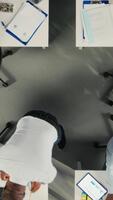 Vertical Top down view zoom out of business people review diagrams during report writing. Colleagues in multinational company share insights and coordinate tasks using pc and visual data tools. Camera A. video
