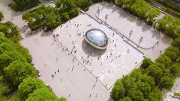 Chicago, Illinois, 2025 - Iconic Cloud Gate surrounded by numerous tourists visiting the site. Top view on the blue cloudy sky reflecting in the big shining Bean. video