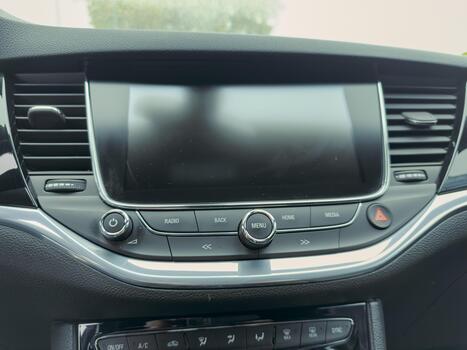 Dashboard technology features a sleek interface with various buttons showcasing modern car design during a daytime drive photo