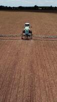 traktor fordon arbetssätt på fält. antenn skott av de traktor medan arbetssätt i de fält video