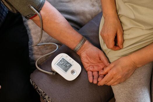 Health monitoring takes place at home during a routine check for blood pressure readings photo